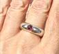 Preview: Ein runder rosaner Rhodolithcabochon ist in einer Goldfassung aus 750er Gold gefasst und sitzt auf einer kräftigen und aus einem Stück gegossenen Ringschiene aus 935er Silber.