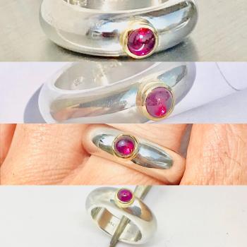 Preview: Ein runder rosaner Rhodolithcabochon ist in einer Goldfassung aus 750er Gold gefasst und sitzt auf einer kräftigen und aus einem Stück gegossenen Ringschiene aus 935er Silber.