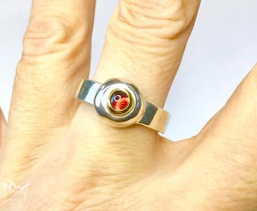 Ein wunderschöner, runder Granat als Cabochon geschliffen und in 18kt Gelbgold gefasst, sitzt auf einem grossen Silbernugget der in der Ringschiene aus 935er Silber sitzt.