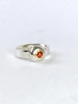 Ein wunderschöner, runder Granat als Cabochon geschliffen und in 18kt Gelbgold gefasst, sitzt auf einem grossen Silbernugget der in der Ringschiene aus 935er Silber sitzt.