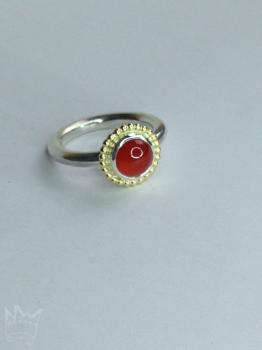 Preview: Ein runder, zinnoberroter, wunderschöner Karneol, sitzt auf einem feinen Silbertellerchen und ist ebenfalls in Sterlingsilber gefasst. Um die Fassung läuft ein feiner Kugelkranz aus 18kt Gelbgold.