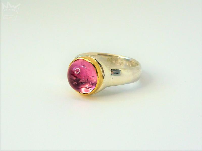 Ein wundervoller, runder,rosaner Turmalin mit lebendigen Wachstumsspuren, in 750er Gelbgold gefasst, sitzt auf einer Ringschiene in 935er Silber.