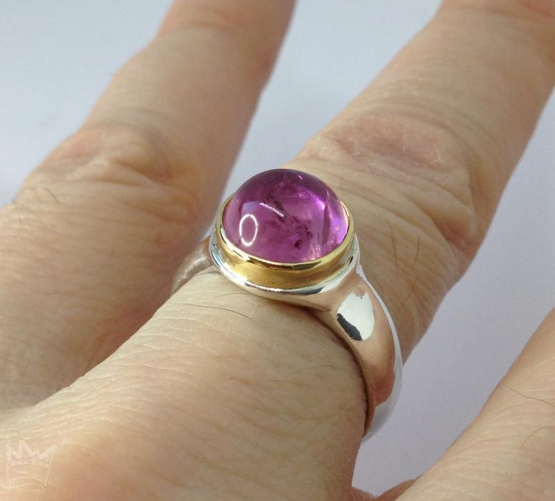 Ein wundervoller, runder,rosaner Turmalin mit lebendigen Wachstumsspuren, in 750er Gelbgold gefasst, sitzt auf einer Ringschiene in 935er Silber.