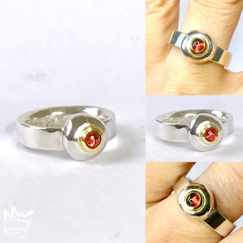 Ein wunderschöner, runder Granat als Cabochon geschliffen und in 18kt Gelbgold gefasst, sitzt auf einem grossen Silbernugget der in der Ringschiene aus 935er Silber sitzt.