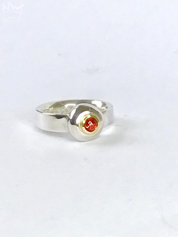 Ein wunderschöner, runder Granat als Cabochon geschliffen und in 18kt Gelbgold gefasst, sitzt auf einem grossen Silbernugget der in der Ringschiene aus 935er Silber sitzt.