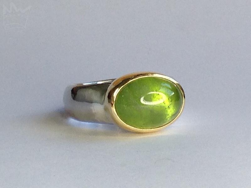 Silberring mit Peridot in Goldeinfassung